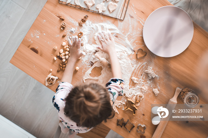 Girl cooking on wooden table at kitchen closeup. Making cookies with nuts.