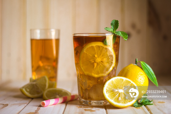 Glasses of ice tea with lemon slices  on wooden background