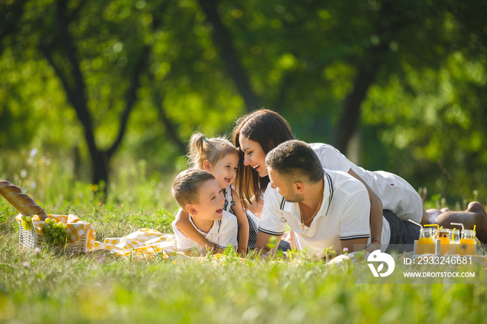 Cheerful family having picnic. Parents having dinner with their kids outdoors.