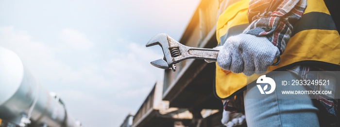 Hands of Engineer woman holding wrench for repair working on train garage site, for banner cover des