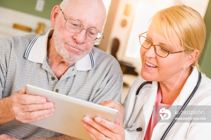 Female Doctor or Nurse Showing Senior Man Touch Pad Computer At Home