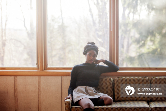 Portrait of young woman sitting on sofa