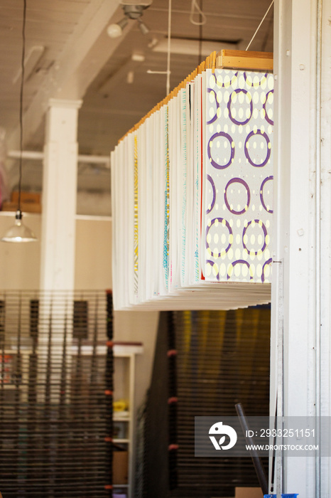 Patterned textiles hanging in printing workshop