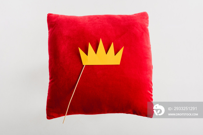 top view of paper crown on red pillow isolated on white