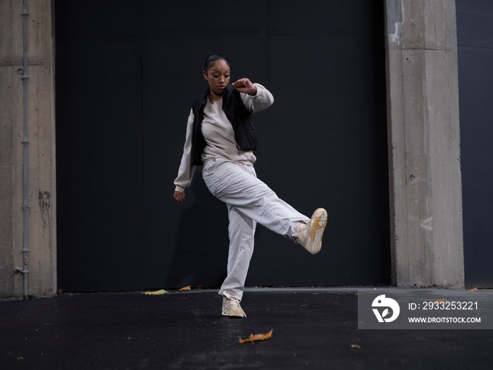 Teenage girl in sports clothing dancing in city