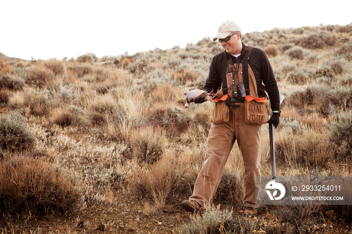 Hunter with dead bird in hand