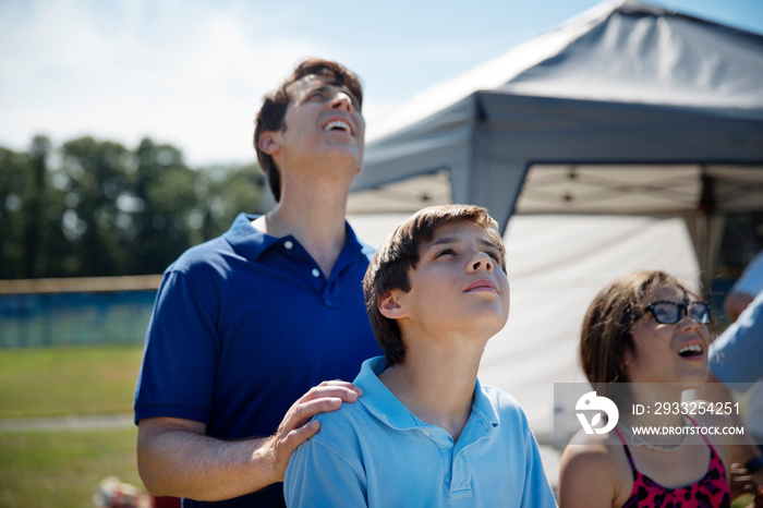 Man looking up to sky with kids (8-9, 10-11)