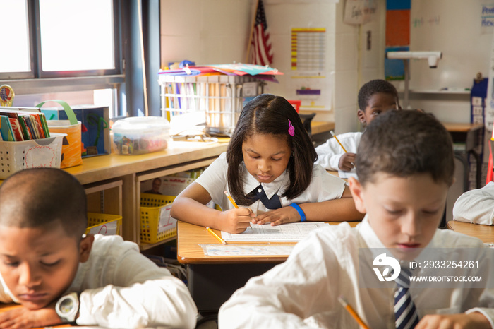 Grade school students (6-7, 8-9) taking test in classroom