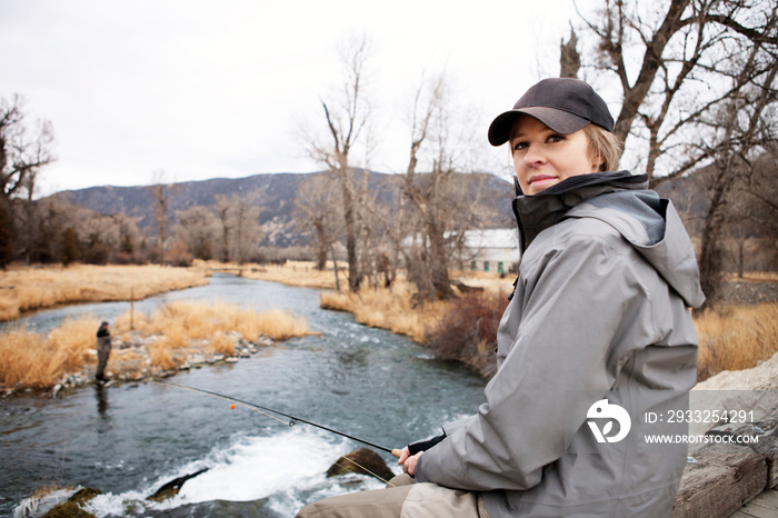 Woman fishing off bridge