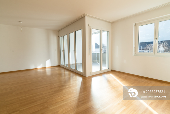 bright new living room in an empty apartment with french doors and parquet wooden floors