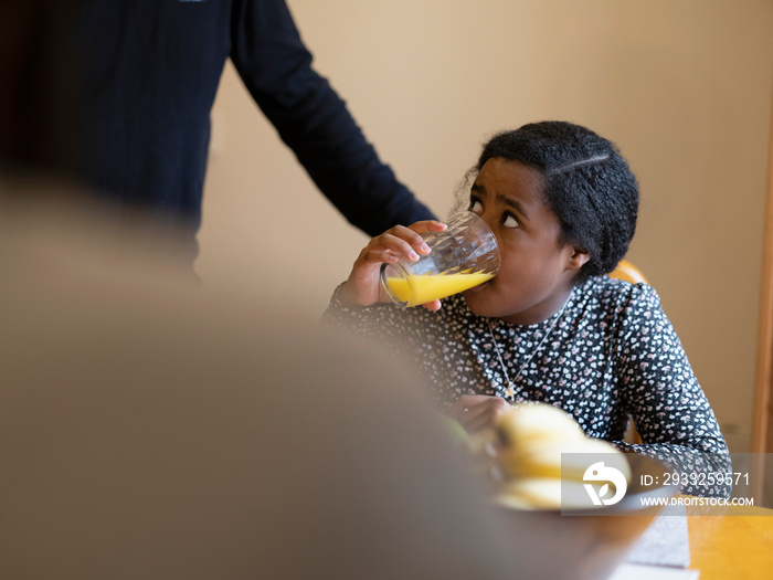 Girl drinking orange juice for breakfast