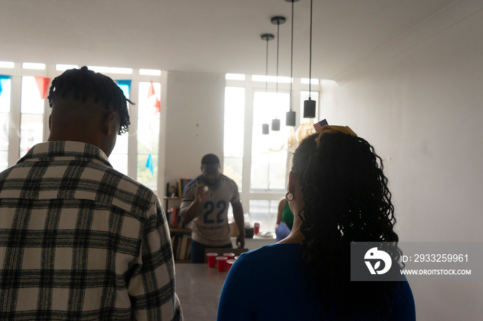 Friends�playing beer pong at home party