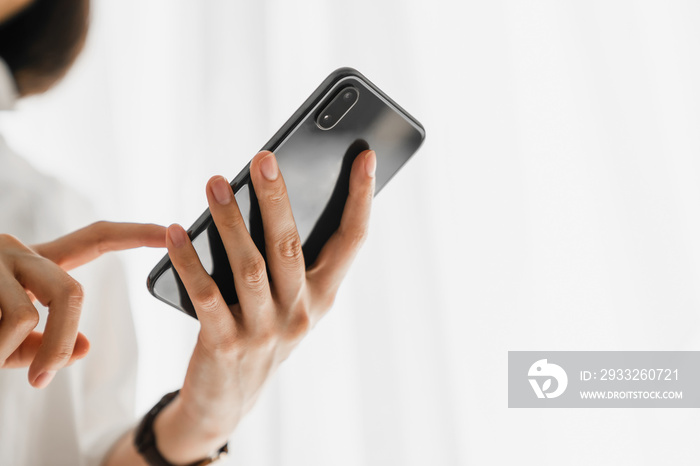 Close-up of hand holding smartphone device and  typing text message on online social.