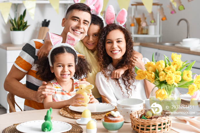 Happy family celebrating Easter at dining table in kitchen