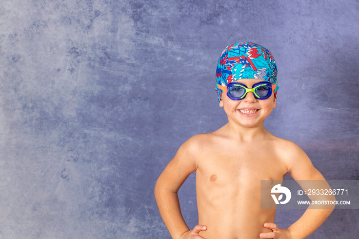 Little kid with a swimming cap and pool glasses