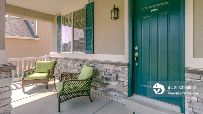 Green front door with two armchairs on the porch