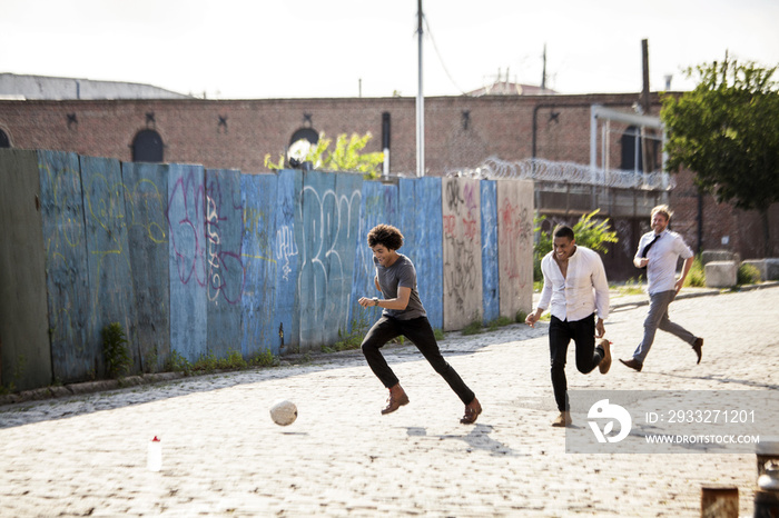 朋友在街上踢足球时跑步