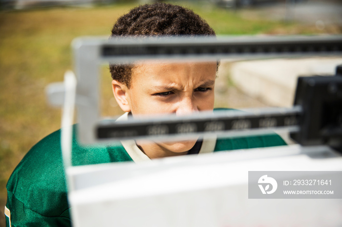 American football player standing on weighing scale