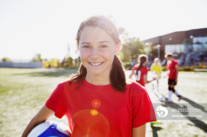 Teenage soccer player holding soccer ball.