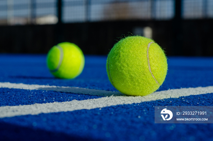 蓝色球拍网球场线上两个球的地面图像