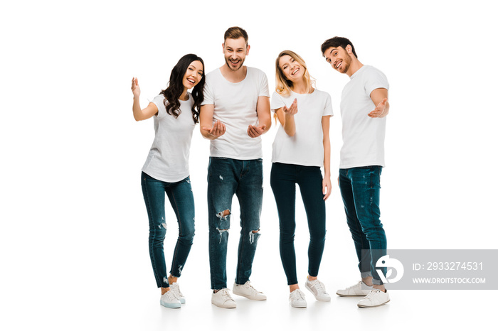 happy young men and women in white t-shirts gesturing with hands and smiling at camera isolated on w