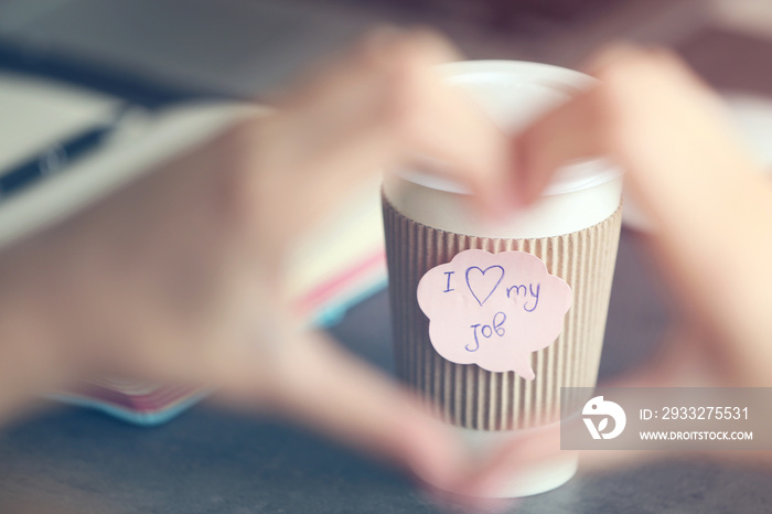 I love my job concept. Female hands in heart shape and cup of coffee