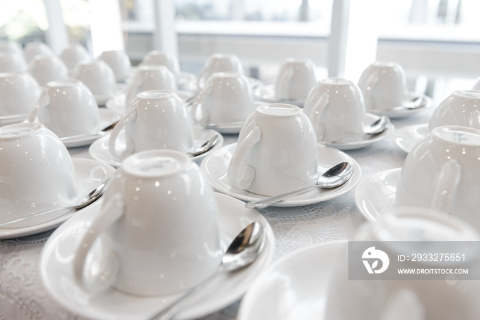 Group of many empty cups with spoons for service coffee or tea in seminar event or meeting room