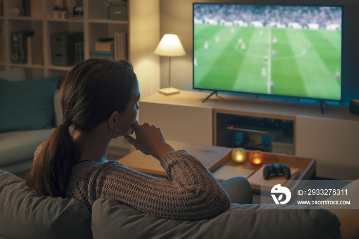 女人在电视上看足球比赛