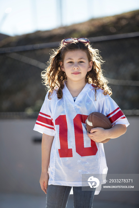 Portrait of smiling girl holding football