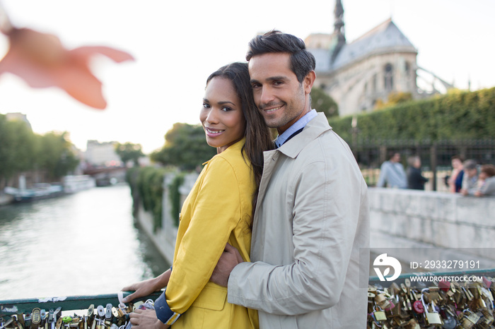 Portrait affectionate couple hugging on Pont des Arts, Paris, France