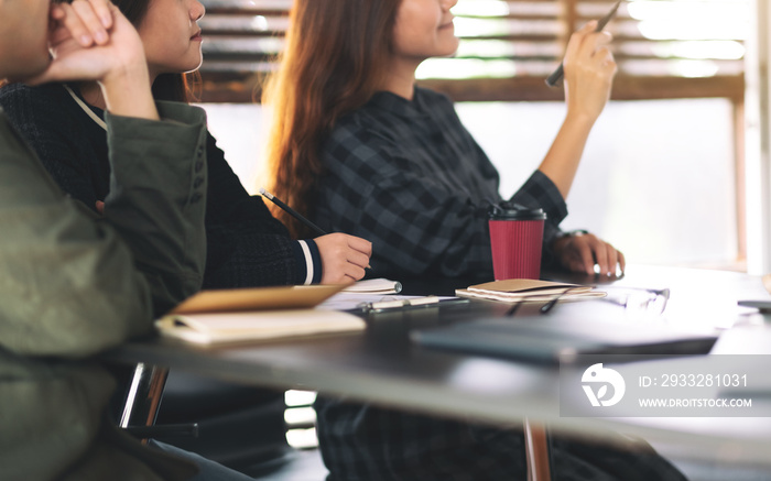 Businesspeople looking and discussing ideas over a board in office