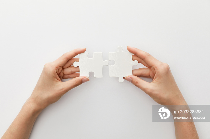 cropped view of woman holding piece of jigsaw puzzle on white background