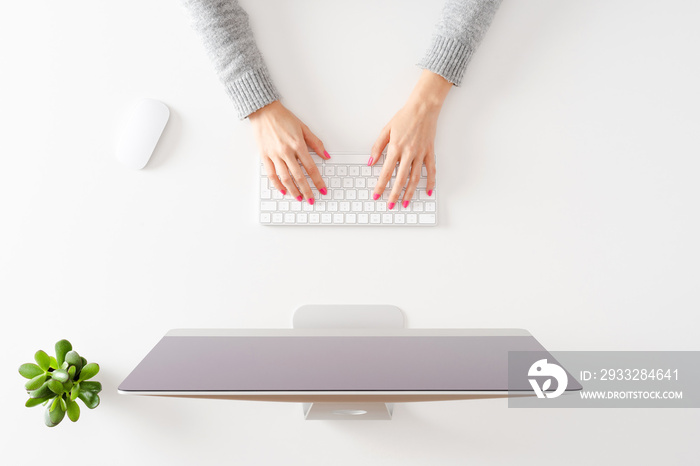 Overhead shot of woman’s hands working on computer