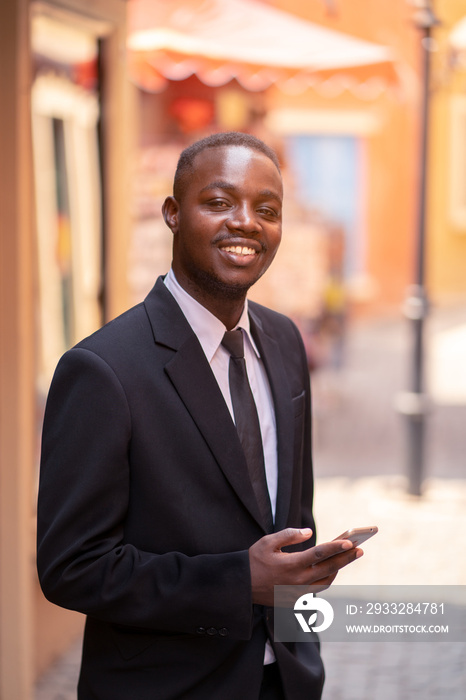 African business man using his smartphone in the city