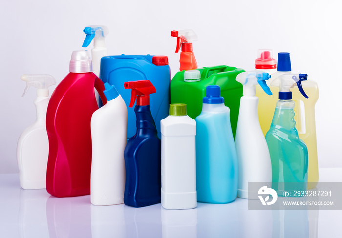 Cleaning concept with various plastic bottles and canisters on white background