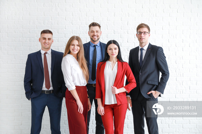 Team of business people near white brick wall