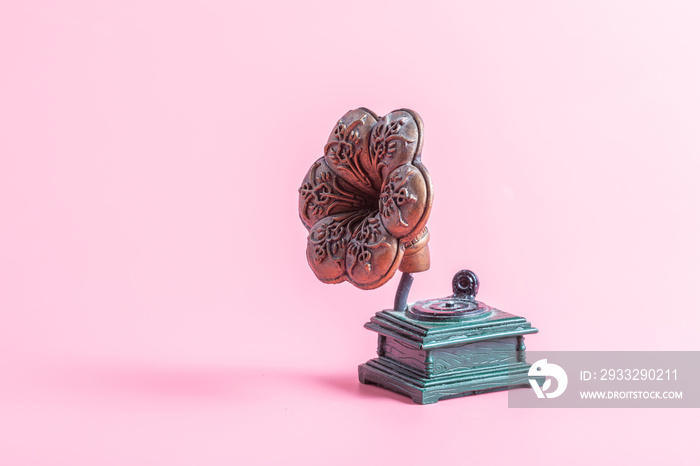 Antique gramophone on a pink background, copper and green