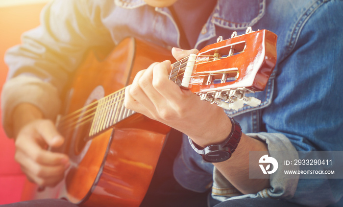 Male musician playing acoustic guitar.