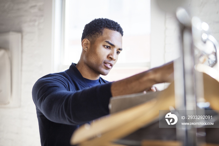 Man choosing clothes from rack at home