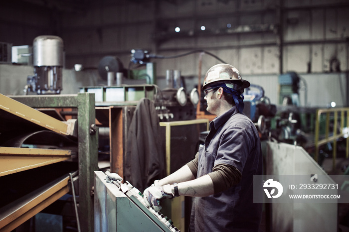 Side view of man working at steel mill