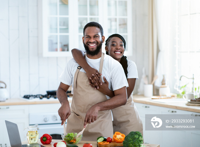 Grateful African American Woman Embracing Husband That Cooking Food In Kitchen