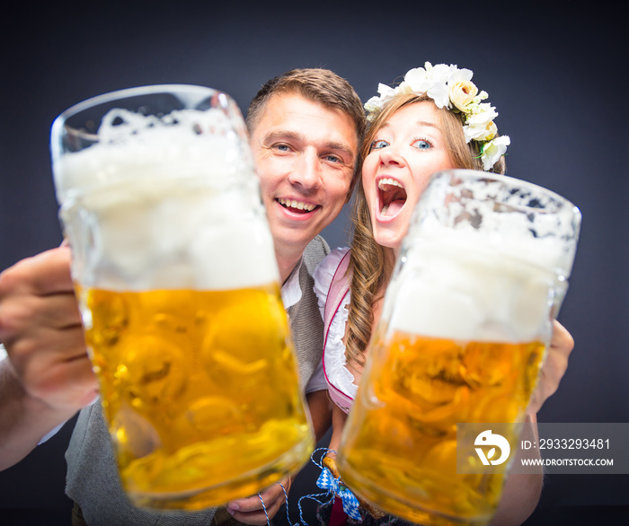 Mann und Frau stoßen mit Maß bier an und lachen auf dem Oktoberfest