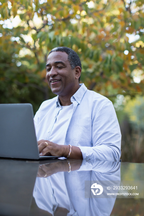 Senior man using laptop on patio