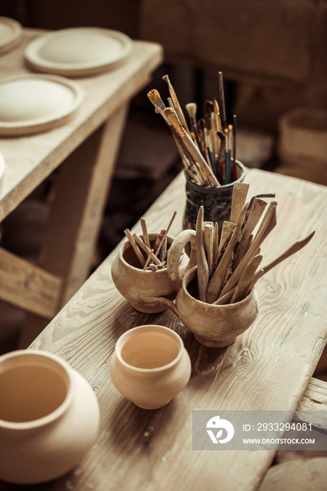 桌子上碗里的画笔和陶器的特写