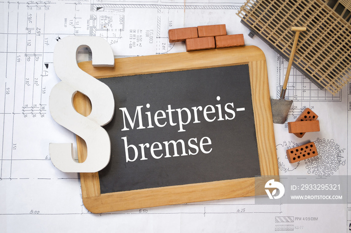 Tafel mit Bauplan und Haus mit段落Recht Mietpreisbremsse