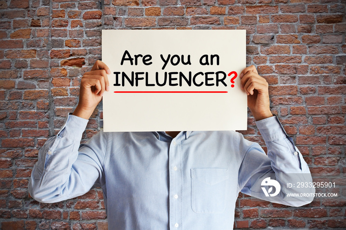 Influencer marketing concept with “are you an influencer” question on white paper in young blogger’s