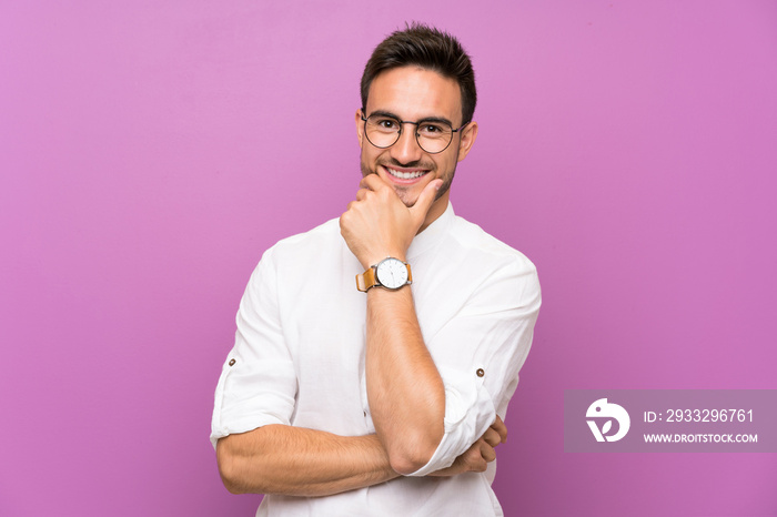 Handsome young man over isolated background with glasses and smiling