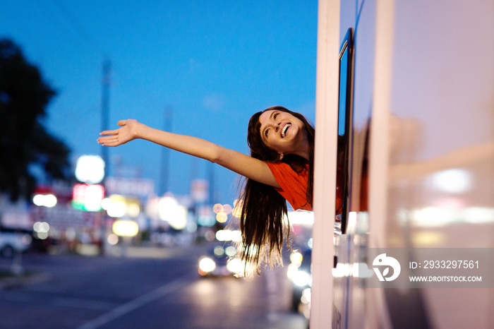 Young woman waving through camper van window