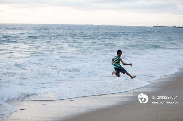 Boy jumping on Huntington Beach, California, USA