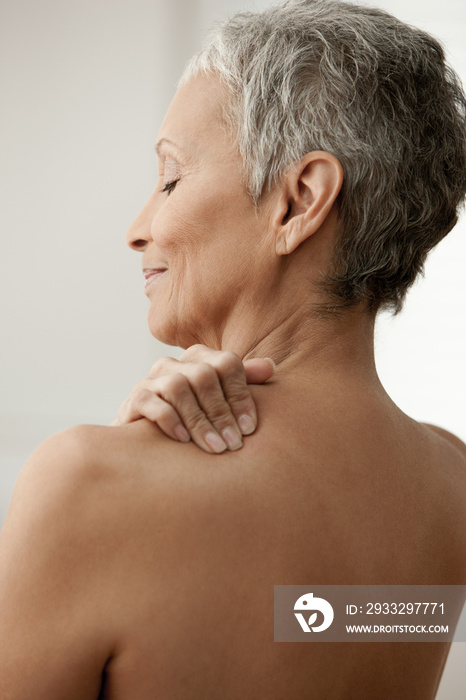 Senior woman massaging shoulder